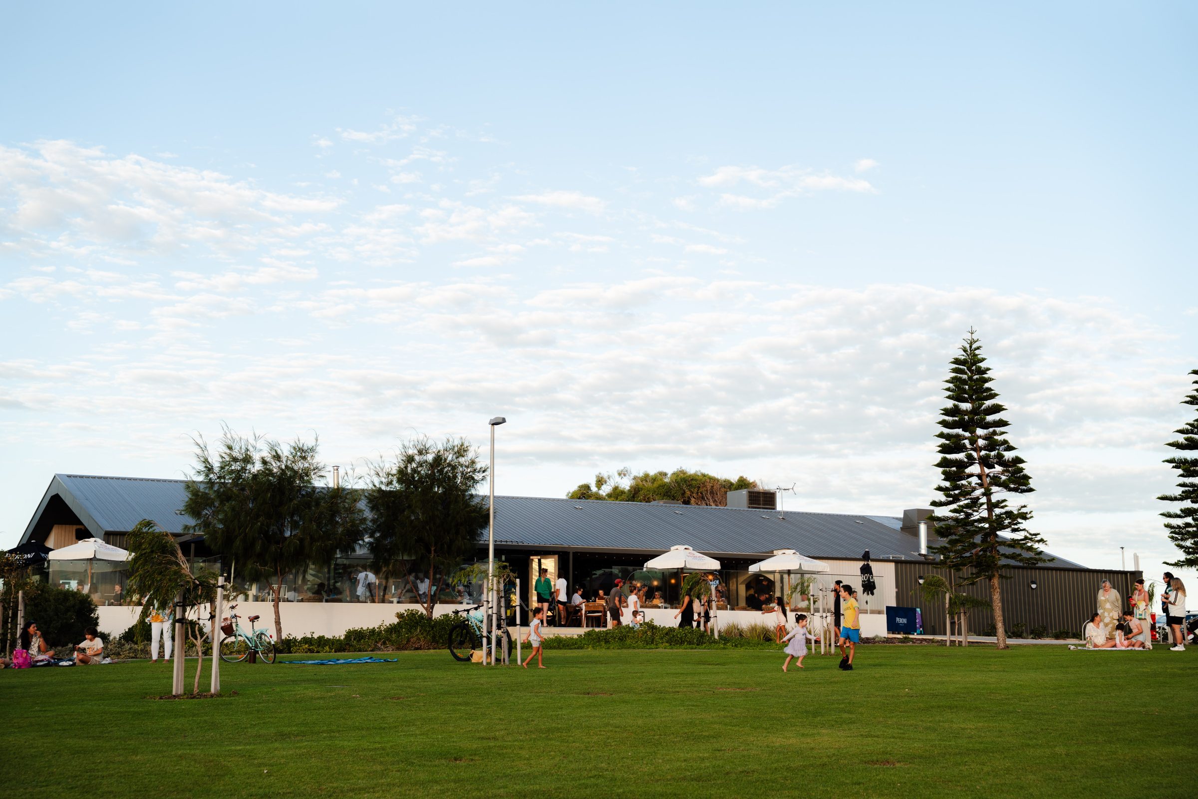 People enjoying the open community space at Yanchep Beach Club near Capricorn Beach.
